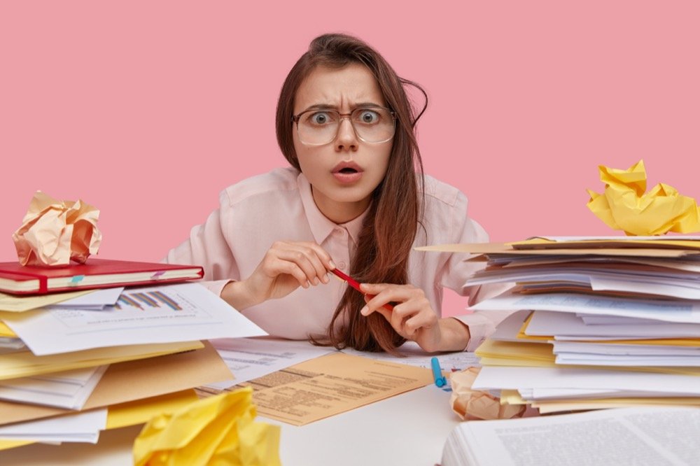 Jeune femme étudiant sur fond rose