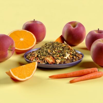 Rooibos vert Carotte Orange et pommes posées sur une table jaune